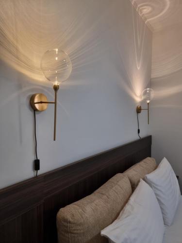 a room with a couch and two lights on the wall at KC Apartments 3 in Berat
