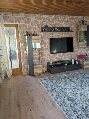 a living room with a tv on a brick wall at Villa Viola 