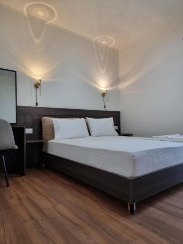 a bedroom with a large bed and a chair at KC Apartments 3 in Berat