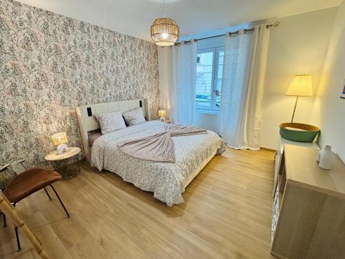 a bedroom with a bed and a table and a lamp at Le Salvator - Mulhouse in Mulhouse