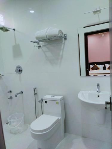a white bathroom with a toilet and a sink at NEW MOUNT RESIDENCY in Sultan Bathery