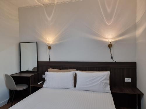 a bedroom with a bed with two lights on the wall at KC Apartments 3 in Berat