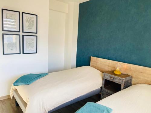2 letti singoli in una camera con pareti blu di "Les Pâturages" Chanas - Maison Entière proche A7, 2 Chambres, 4 Personnes, Jardin Privé, Piscine & BBQ a Chanas