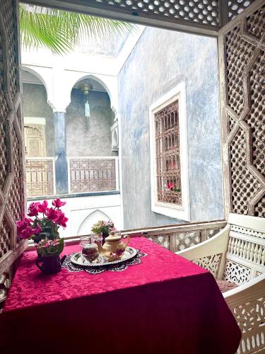 a room with a table with a red table cloth at Riad Green Palm in Marrakech