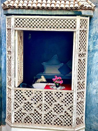 a room with a bed and a table with flowers at Riad Green Palm in Marrakech