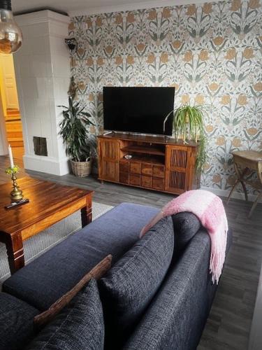 a living room with a couch and a flat screen tv at Kulla Skola in Veddige