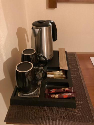 a tray with a coffee maker and two cups on it at HOTEL ΗΩ (ΞΕΝΩΝΑΣ ΤΣΙΑΧΡΗΣ) in Morfovoúnion