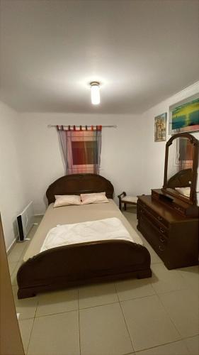 a bedroom with a bed with a dresser and a mirror at Felix Villa in Nea Plagia