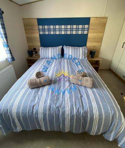 a bed with two towels on top of it at Wanderers Haven, Brigham, Cockermouth, Cumbria in Brigham