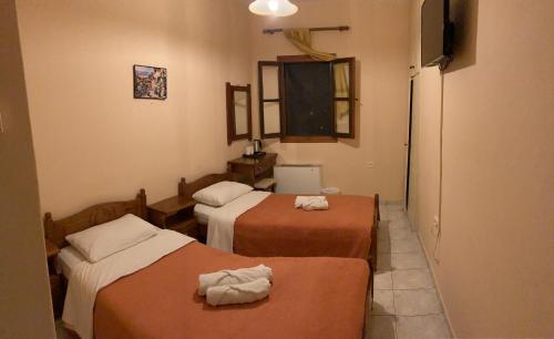 a hotel room with two beds and a television at HOTEL ΗΩ (ΞΕΝΩΝΑΣ ΤΣΙΑΧΡΗΣ) in Morfovoúnion