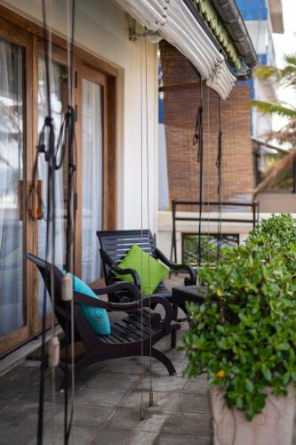 a porch with two chairs and an umbrella at Villa 46 in Hikkaduwa