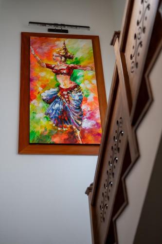 a painting of a woman in a dress on a wall at Villa 46 in Hikkaduwa