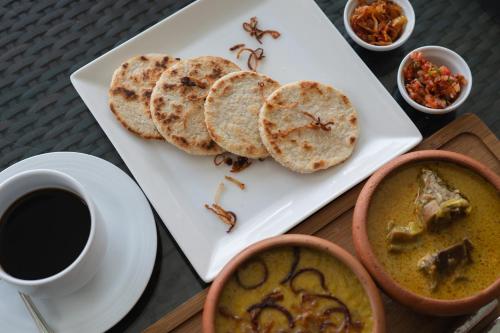 a plate of food with bread and a cup of coffee at Villa 46 in Hikkaduwa