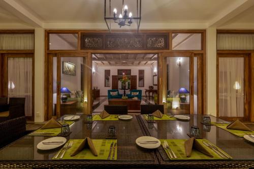 a dining room with a table with yellow place settings at Villa 46 in Hikkaduwa
