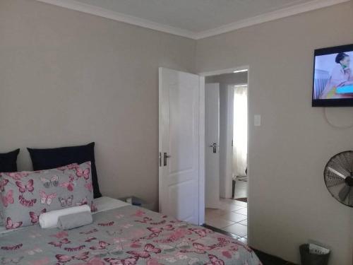 a bedroom with a bed and a tv on the wall at Encome Guest house in Pongola