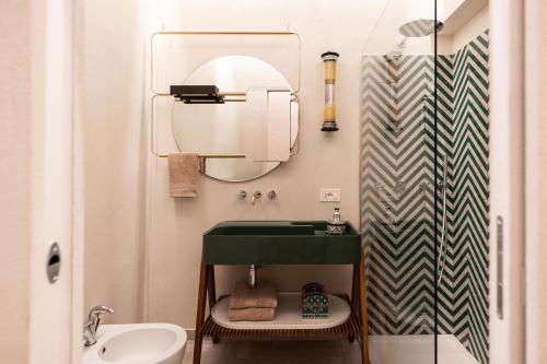 a bathroom with a green sink and a mirror at Le Dimore di Rosa e Vincenzo in Bari