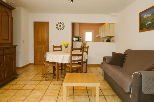 a living room with a table and a couch and a kitchen at Gites Bulanettes 'Bergerie' Sainte Marie de Campan in Campan