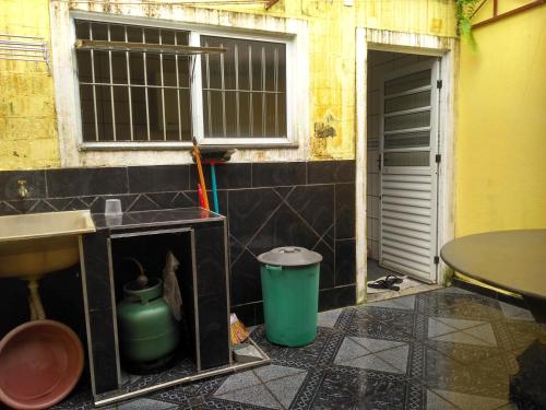 - une cuisine avec évier, fenêtre et poubelle dans l'établissement que delicia de lugar, à Itanhaém