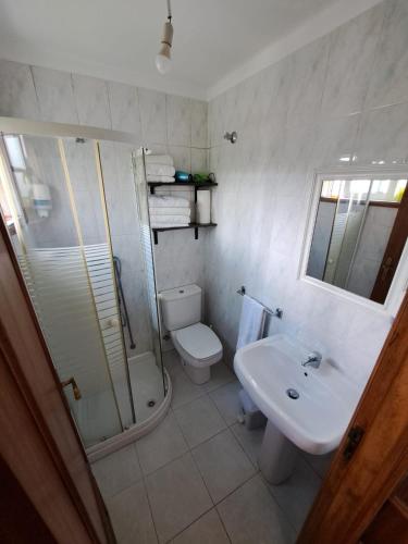 a bathroom with a shower and a toilet and a sink at Casa Azélia e Albino in Aves