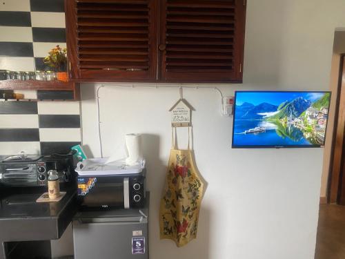 a kitchen with a sink and a tv on the wall at Shikos Place in Watamu