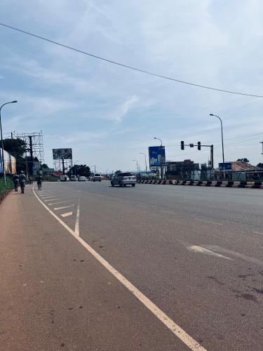 a car driving down a street with a traffic light at 1 minute walk to Victoria Mall in Entebbe