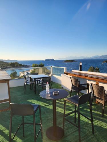 a patio with tables and chairs and the ocean at Ventus Hotel in Ksamil
