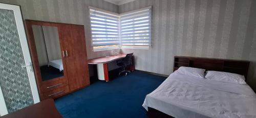 a bedroom with a bed and a desk and a sink at Independent Apartment in Antananarivo in Antananarivo
