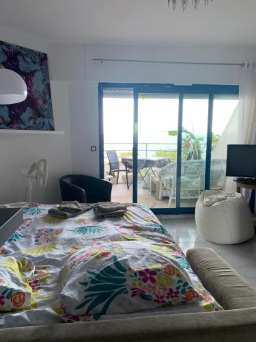 una camera da letto con un letto con una coperta colorata sopra di Studio calme vue mer pieds dans l'eau a Saint-Raphaël