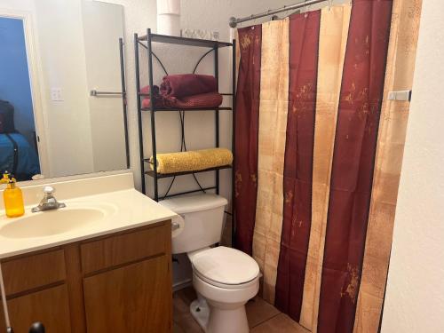 a bathroom with a toilet and a shower curtain at The Bobcat in San Marcos