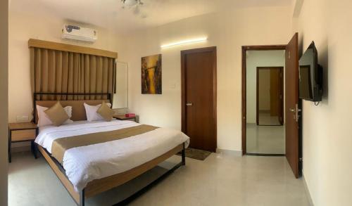 a bedroom with a bed and a television in it at DeVerveil Mysore in Mysore