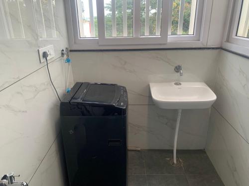 a small bathroom with a sink and a white sink at DeVerveil Mysore in Mysore