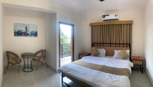 a bedroom with a large bed and a table and chairs at DeVerveil Mysore in Mysore