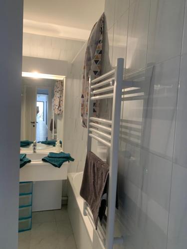 un bagno con un lavandino, una vasca e uno specchio di Studio calme vue mer pieds dans l'eau a Saint-Raphaël