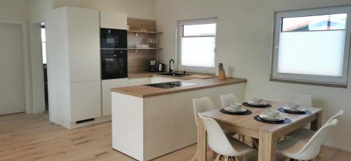 a kitchen with a table and chairs and a kitchen with a table and a kitchen at Ferienhaus-Elbblick-Haselau in Haselau
