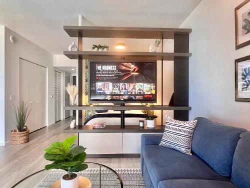 a living room with a blue couch and a tv at SPECIAL OFFER - Luxury High Rise Downtown Miami - Bay Views and Top Amenities in Miami