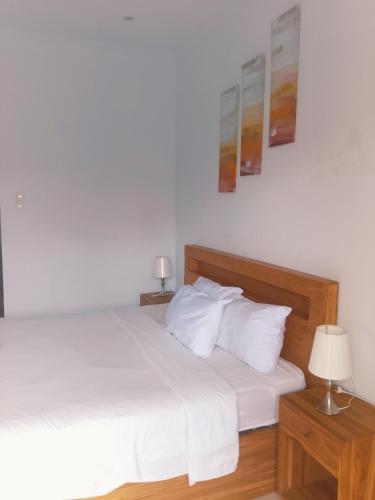 a bedroom with two beds with white sheets and two lamps at wirati Jeneng Guest house in Kerobokan