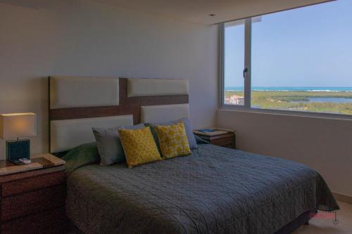 a bedroom with a bed and a large window at Condo Blue Lagoon Cancun-Espectacular Vista in Cancún