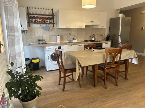 una cucina con tavolo e sedie e una cucina con frigorifero di La Sosta del Viaggiatore a Sulmona