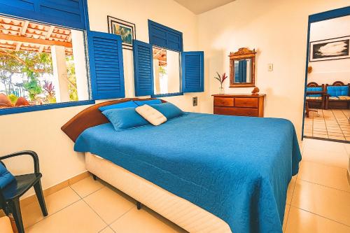 a bedroom with blue shuttered windows and a bed at Morada da Praia - Porto de Pedras à Beira-Mar in Pôrto de Pedras