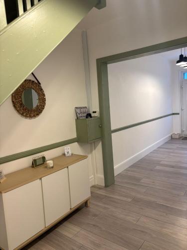 a room with a door and a table and a mirror at The Bohe Home in Wallasey