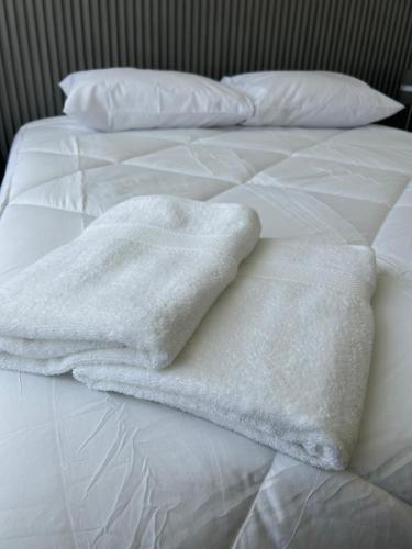two white towels sitting on top of a bed at Casa elegante privada y moderna in Coquimbo