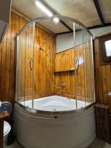 a bath tub in a room with wooden walls at İncir Bungalov Karavan Park Efes-Kuşadası in Aydın