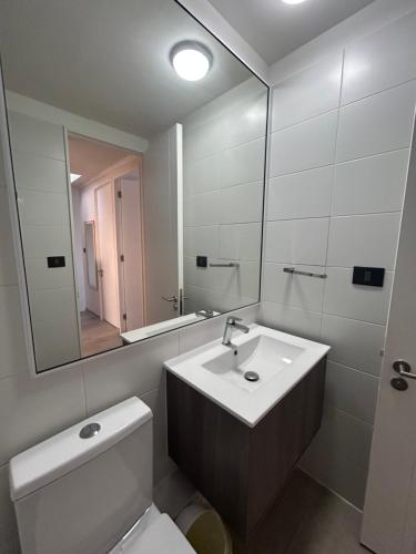 a bathroom with a sink and a toilet and a mirror at Casa elegante privada y moderna in Coquimbo
