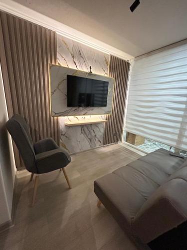a bedroom with a bed and a chair and a television at Casa elegante privada y moderna in Coquimbo