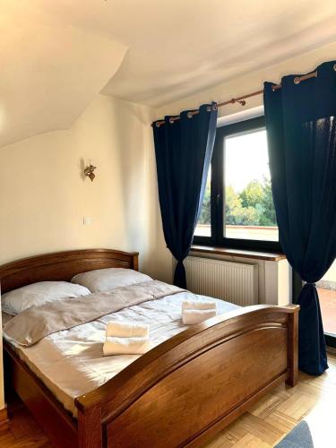 a bedroom with a large bed with blue curtains at Hotel Familiar in Kobyłka