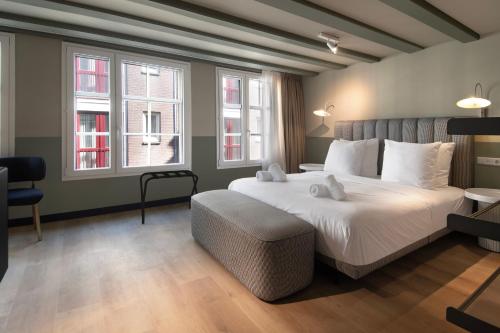 a bedroom with a large bed and two windows at Hotel Zeedijk City Centre in Amsterdam