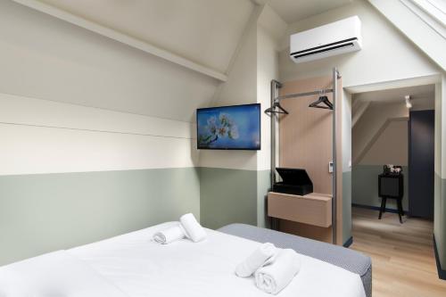a bedroom with a bed and a tv on the wall at Hotel Zeedijk City Centre in Amsterdam