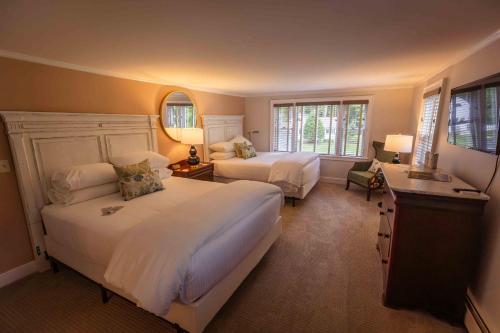 a bedroom with two beds and two windows at Barrows House in Dorset