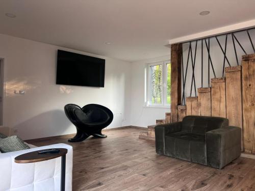 a living room with a black chair and a couch at Glamping "Letnisko WISOLA" in Ciemnik