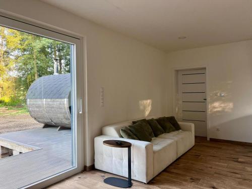 a living room with a couch and a sliding glass door at Glamping "Letnisko WISOLA" in Ciemnik